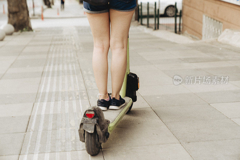 学生骑着电动滑板车穿过市区