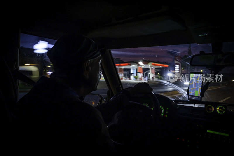 夜间在高速公路上驾驶SUV的男子看着导航。