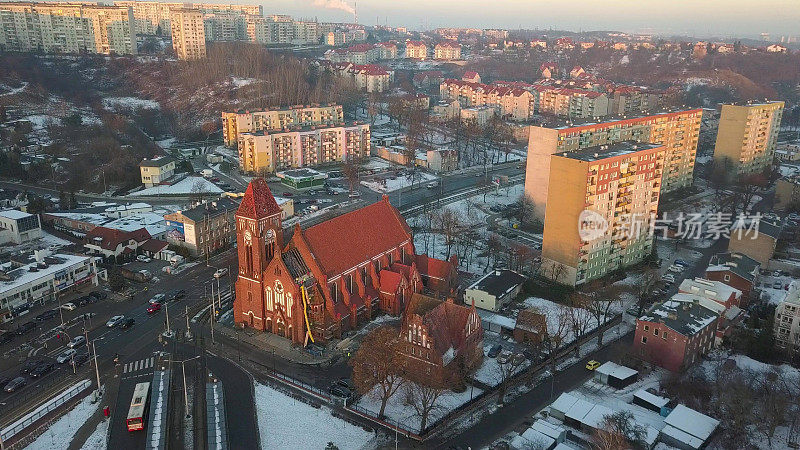 冬季被公寓楼包围的哥特式砖砌教堂航拍图