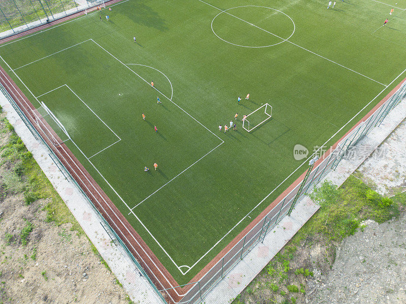 足球运动员在草地上进行比赛的鸟瞰图。空中室外体育场人造草