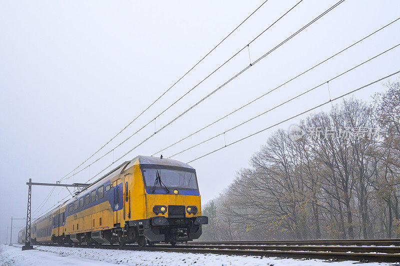 荷兰铁路公司的城际列车行驶在雪地上