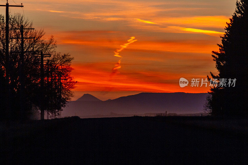 落基山脉阴云密布的夕阳被树木衬托着