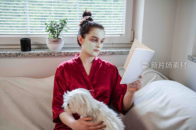 带着面膜的女人读书和抚摸狗