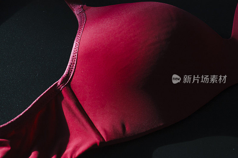 红色无缝平滑无衬里妇女推胸罩在黑色的背景。
