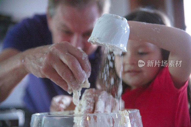 孙女倒了一杯面粉，爷爷撒在厨房的碗里。