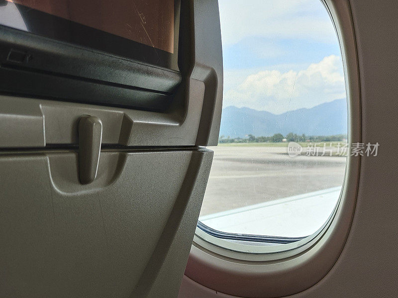 后视图的经济舱飞机窗口。乘飞机旅行的概念