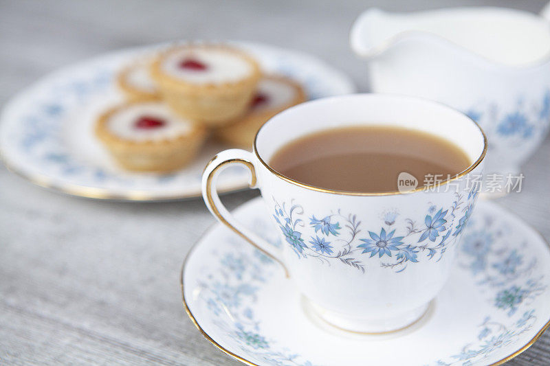 一杯茶和樱桃贝克威尔馅饼在一个轻木制表面