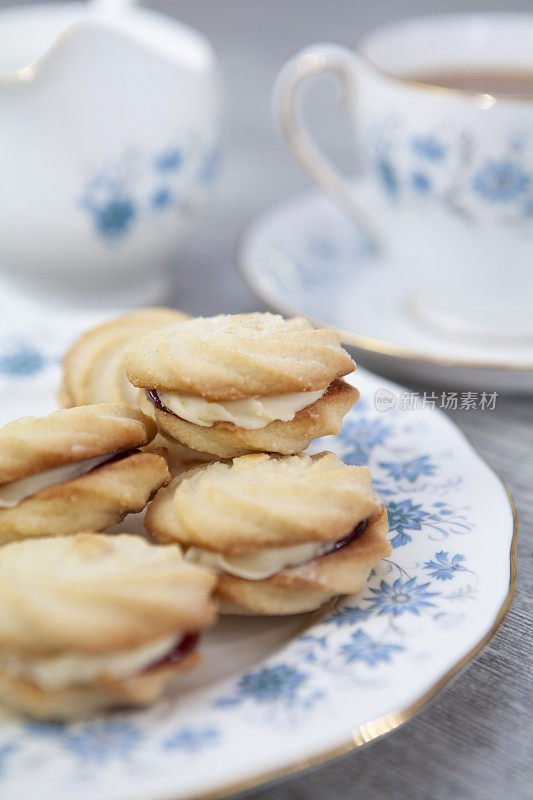 维也纳茶碟在装饰盘上旋转，茶杯和茶碟放在一个轻木制的表面上