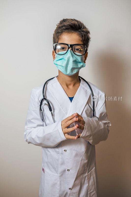 快乐的孩子立志成为一名医生，穿着实验室大褂，戴着听诊器