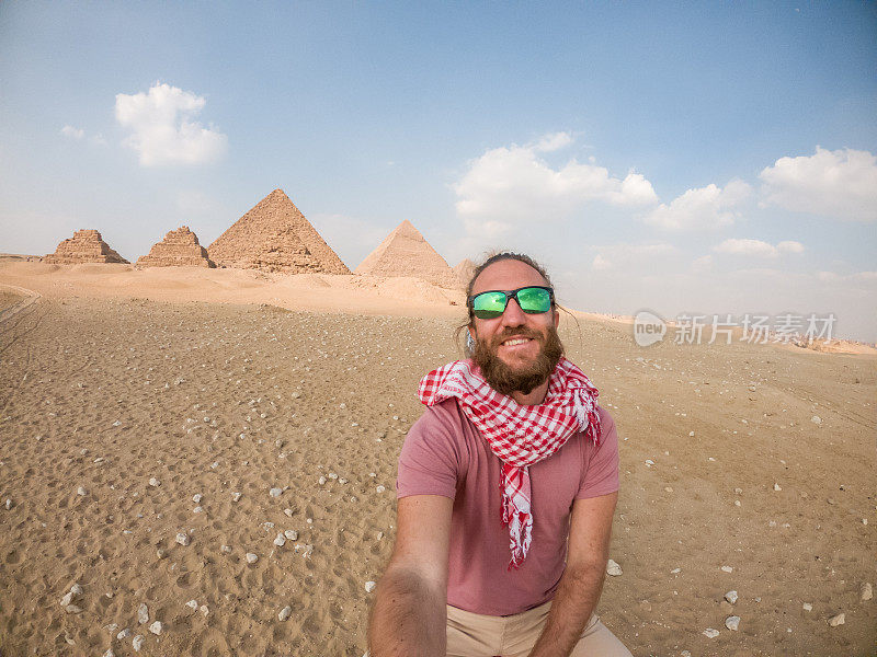 一男子骑着骆驼自拍，背景是金字塔
