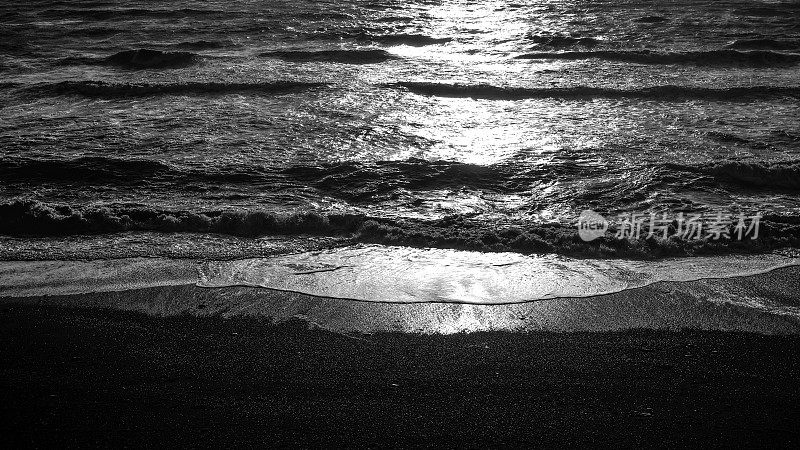 夕阳西下时，海浪翻滚在海滩上