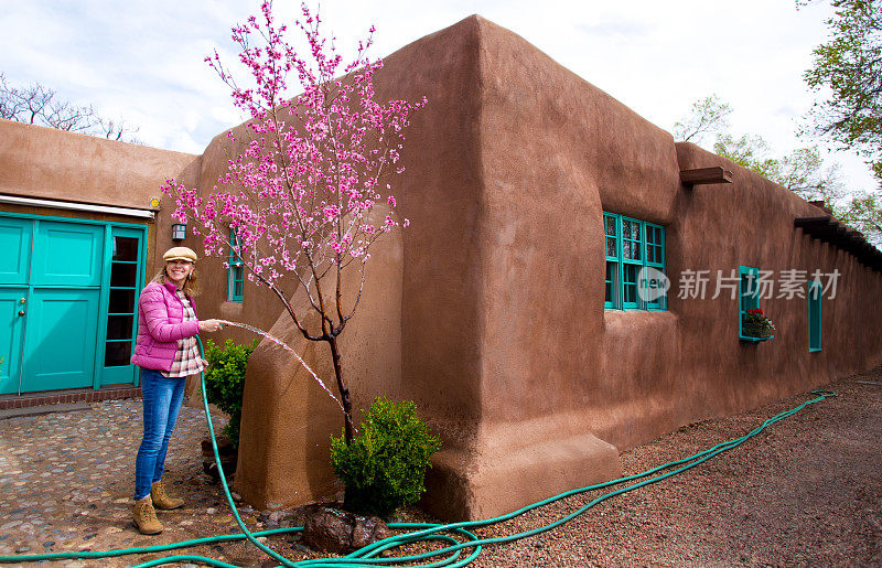 春天园艺:女人浇灌开花的果树