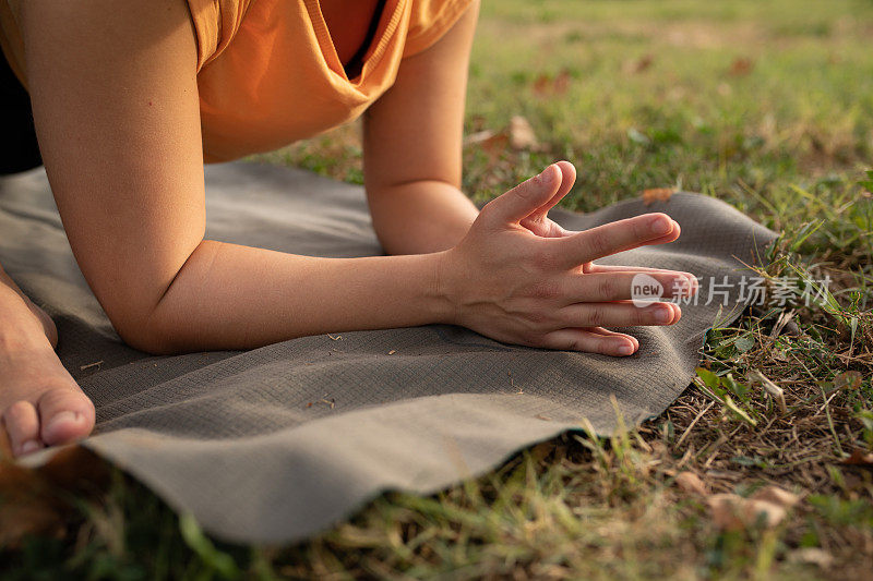 近距离观察一个陌生的年轻女子在公园里做瑜伽