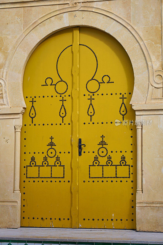 突尼斯的黄色国门。温暖城市的街道建筑。