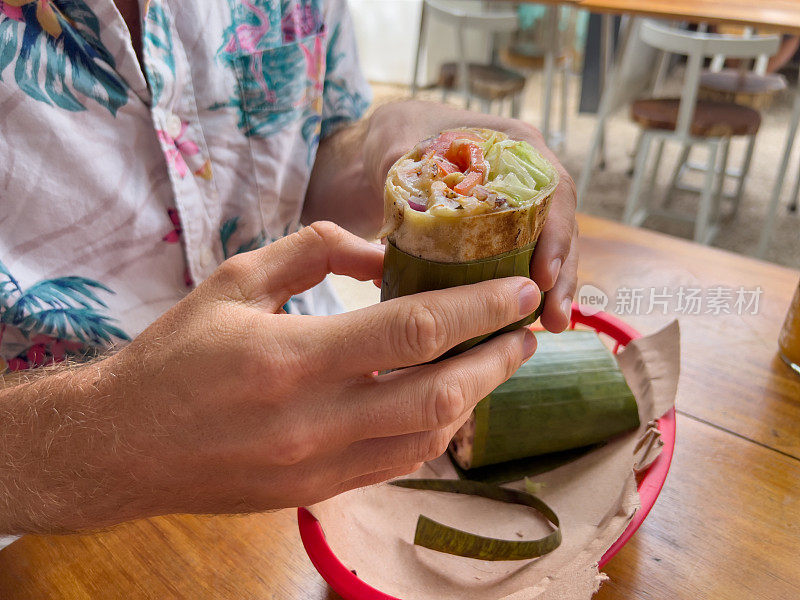 一个在墨西哥吃素食玉米煎饼的年轻人