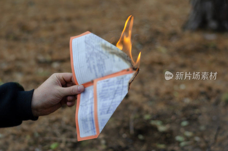 一名男子烧掉了一张手写的纸。