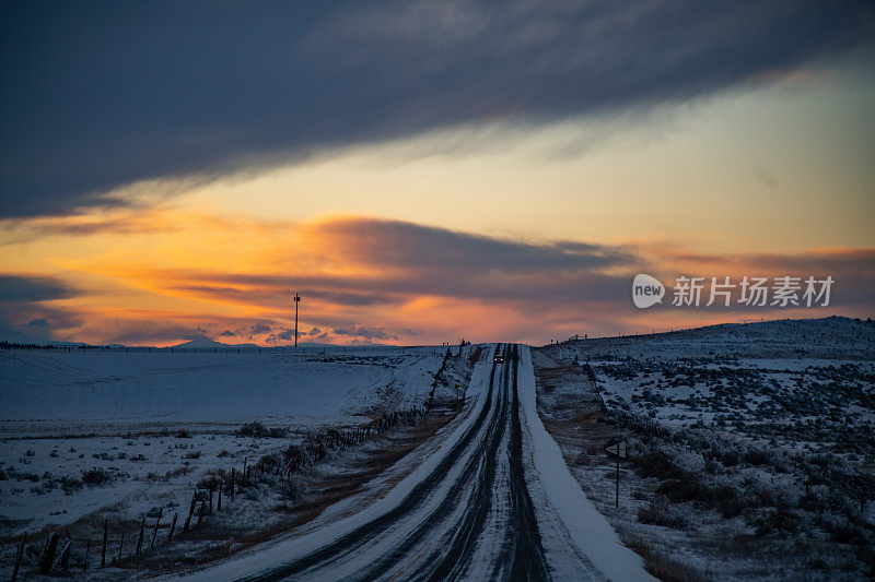 日落时分，积雪覆盖了穿过蒙大拿山区的2车道公路