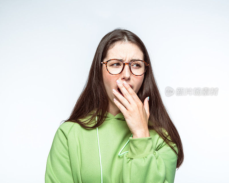 女人在白色背景下打哈欠