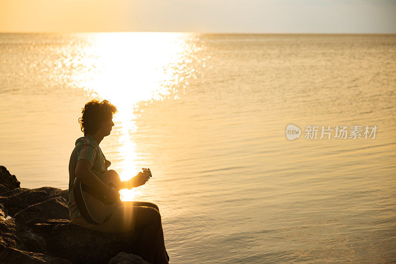 男人在海边弹吉他