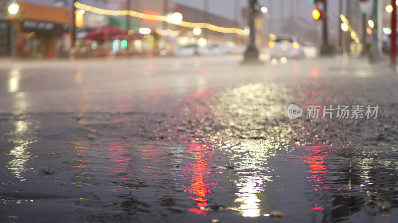 灯光反射，雨天道路。雨点，潮湿的城市街道沥青