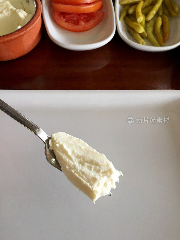 吃酸奶，酸奶放在叉子上，开胃菜放在餐桌上
