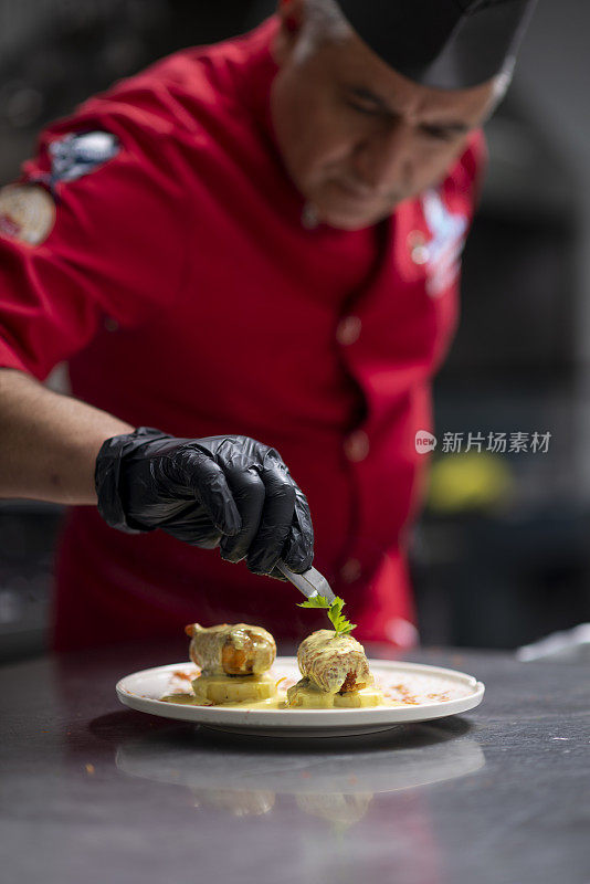 厨师正在厨房里装饰盘子