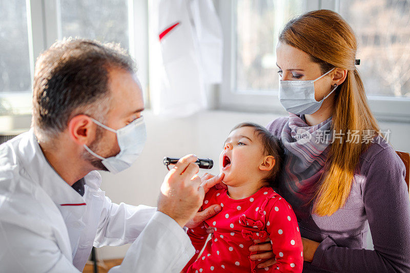 儿科医生正在检查小女孩的喉咙