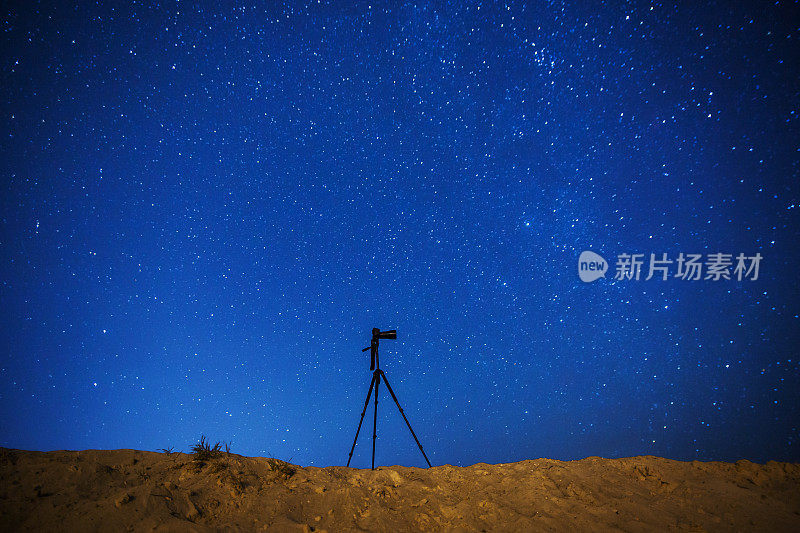 摄影相机在三脚架上的背景上的夜空星空。星星。景观