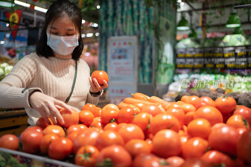 亚洲妇女正在摘西红柿