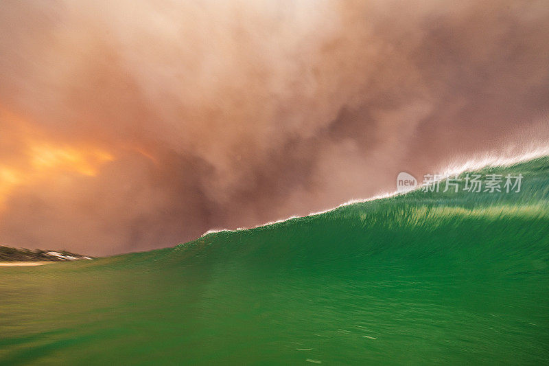 天空中的火，因为浓密的黑烟云形成的丛林火灾反映在海洋表面