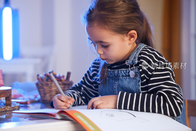 可爱的小女孩用彩色蜡笔画画