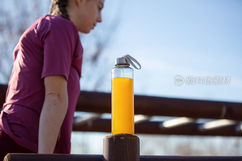 年轻女子在户外运动期间在外面补水。