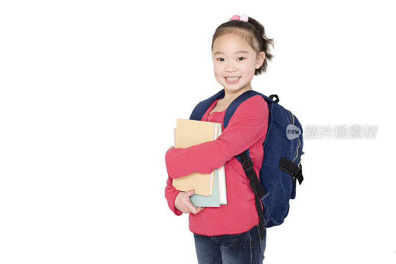 背着书包的小女孩抱着图书