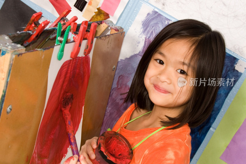一个小女孩在画架上画画