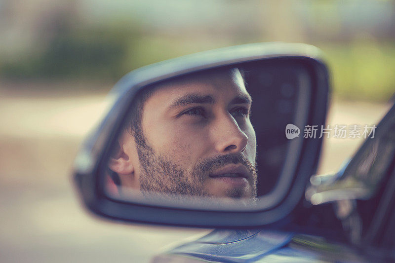 侧面的镜子，一个男人开着他的新车