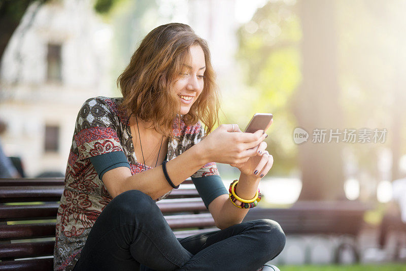 年轻女子用智能手机玩得很开心