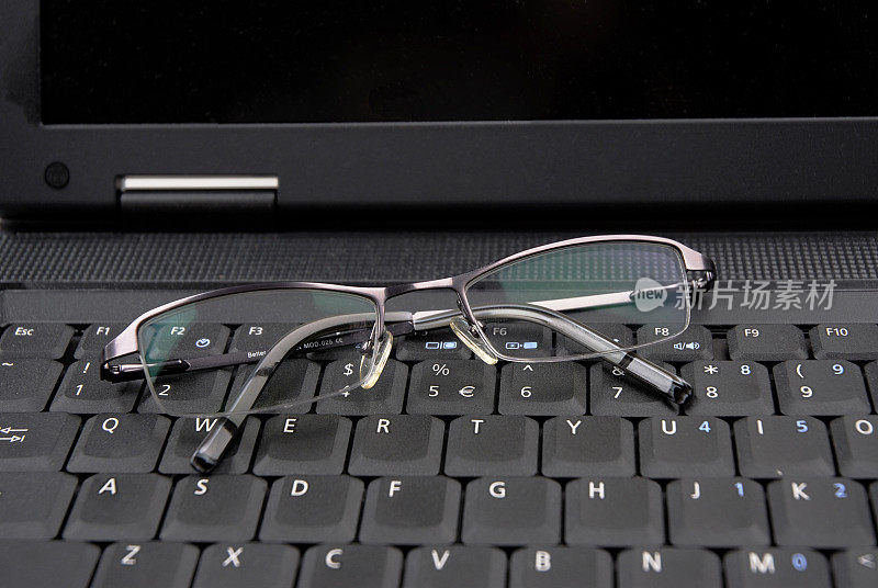 带眼镜的笔记本电脑键盘