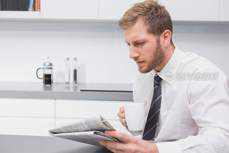 一边喝咖啡一边看报纸的商人