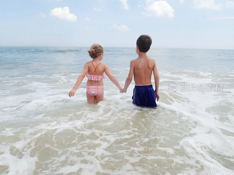 哥哥和妹妹手牵着手在海里