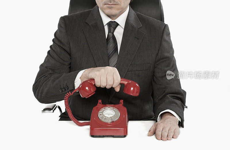 商人挂起红色老式电话听筒