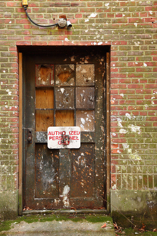 废弃的工厂门，窗户破损，门面老化