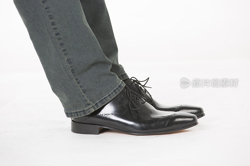 男士牛仔裤和黑色鞋子的特写