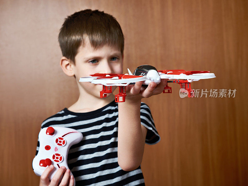 带着玩具四旋翼无人机的小男孩