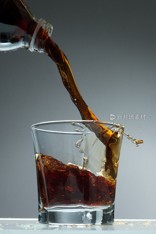 可乐洒在玻璃杯里