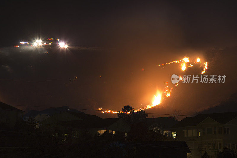 绿色山火，科罗拉多州莱克伍德消防队员在房屋上空燃烧