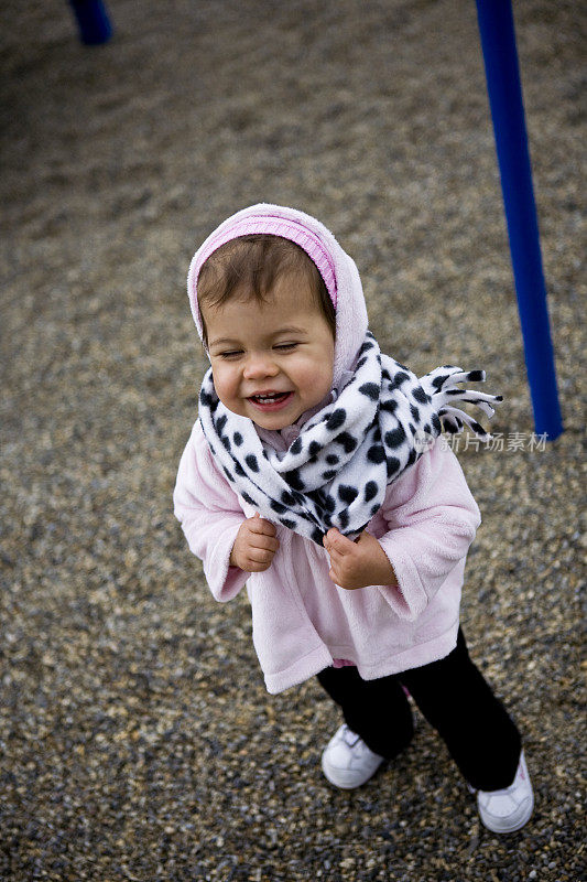 快乐的小女孩穿着冬天的大衣和围巾