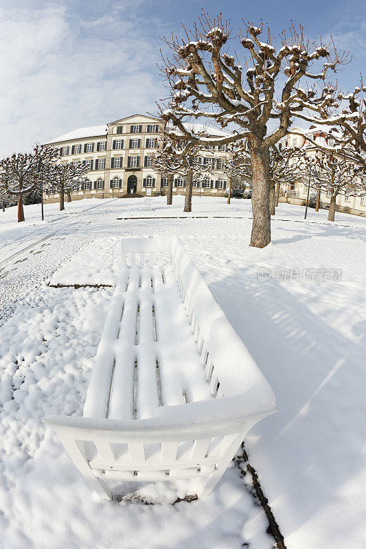 白雪覆盖的公园冬季长椅和人行道德国