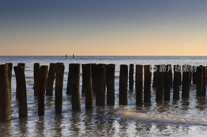 沿着荷兰海岸拍打着木制防波堤的海浪