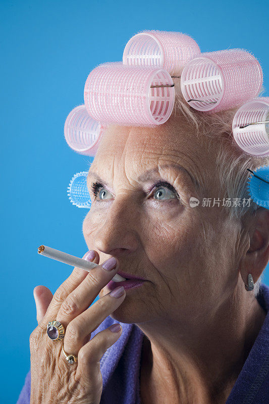 带卷发器的老女人在抽烟