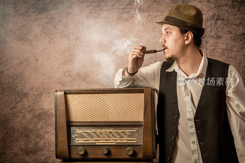 老古董在收音机旁边抽烟斗
